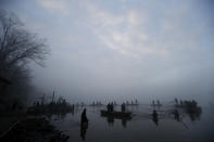 In this picture taken on Thursday, Nov. 15, 2018, fishermen on small boats pull on nets during the traditional fish haul of the Krcin pond near the village of Mazelov, Czech Republic. Czechs will have to pay more for their traditional Christmas delicacy this year after a serious drought devastated the carp population this year. (AP Photo/Petr David Josek)