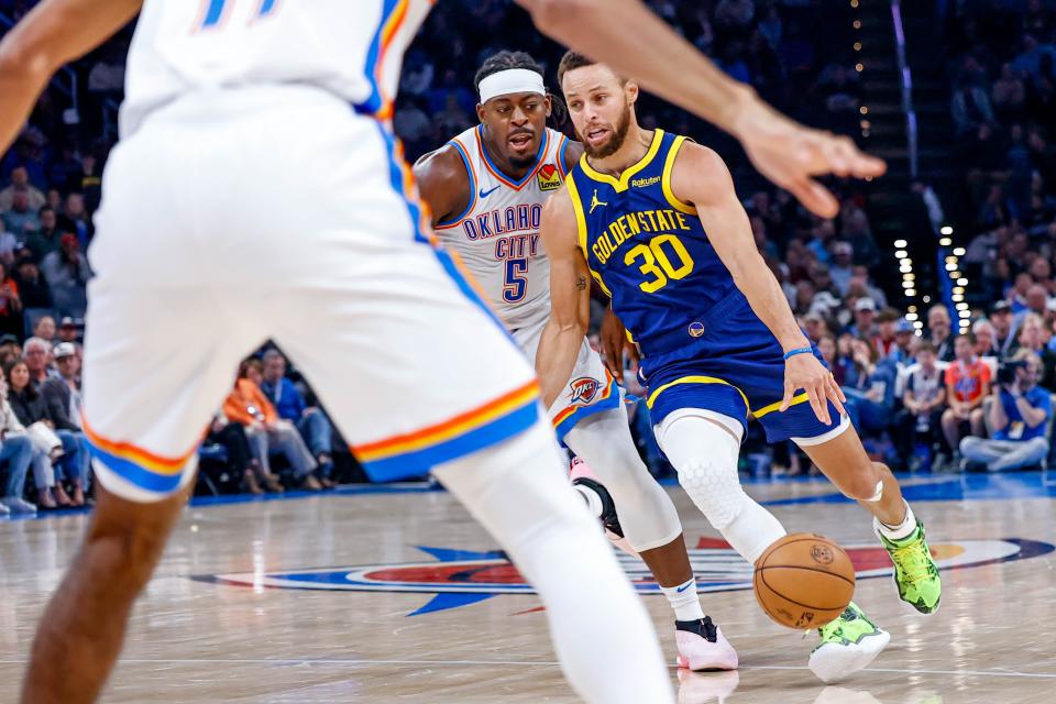 Golden State guard Stephen Curry (30) works up court past Oklahoma City guard Luguentz Dort (5) in the second quarter during an NBA game between the Oklahoma City Thunder and the Golden State Warriors at the Paycom Center in Oklahoma City, on Friday, Dec. 8, 2023.