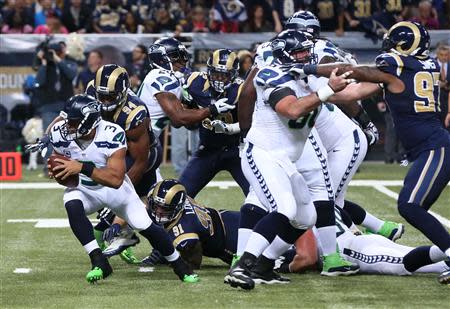 Oct 28, 2013; St. Louis, MO, USA; Seattle Seahawks quarterback Russell Wilson (3) is sacked by St. Louis Rams defensive ends Chris Long (91) and Robert Quinn (94) during the first quarter at Edward Jones Dome. Mandatory Credit: Nelson Chenault-USA TODAY Sports