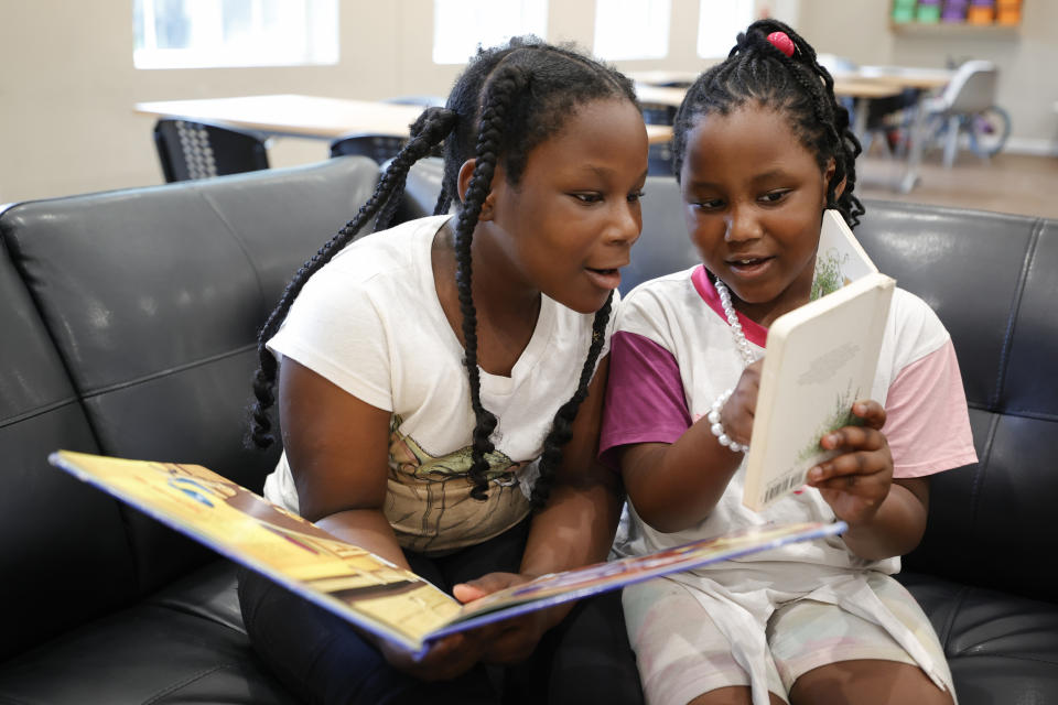 China Nash, 8, left, and Star Shields, 7, read together during a daily after-school literacy program in Atlanta on Thursday, April 6, 2023. The after-school program is open to students in kindergarten through fifth grade through the Atlanta based Pure Hope Project. (AP Photo/Alex Slitz)