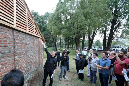 Japanese architect Shigeru Ban (C) shows a prototype of the Nepal House Project in Kathmandu October 19, 2015. REUTERS/Shigeru Ban Architects/Handout via Reuters