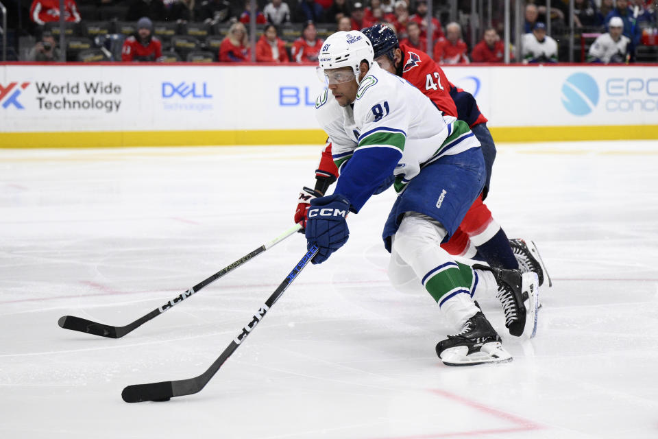 Vancouver Canucks center Dakota Joshua (81) skates with the puck against Washington Capitals defenseman Martin Fehervary (42) during the second period of an NHL hockey game, Sunday, Feb. 11, 2024, in Washington. (AP Photo/Nick Wass)