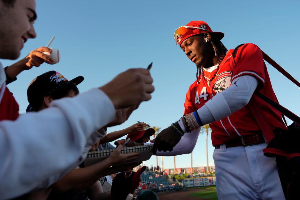 Cincinnati Reds' Elly De La Cruz, right, gives autographs before a spring training baseball game against the Los Angeles Dodgers, Thursday, Feb. 29, 2024, in Goodyear, Ariz.