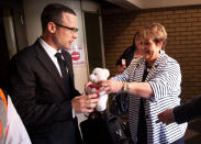 A supporter hands Oscar Pistorius a teddy bear in court during his ongoing murder trial in Pretoria, South Africa, Tuesday, May 13, 2014. Pistorius is charged with the shooting death of his girlfriend Reeva Steenkamp on Valentine's Day in 2013. (AP Photo/Daniel Born, Pool)