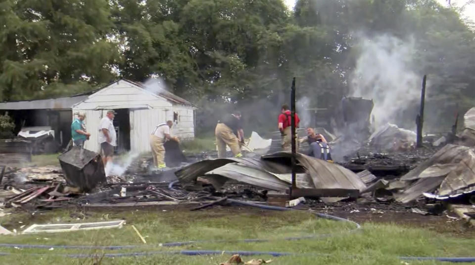 This photo from video by KFVS-TV shows people working the scene of a house explosion in Wyatt Mo., early Monday, Aug. 15, 2022. The house explosion in southeast Missouri has left several people injured and a neighboring home in flames, authorities say. (KFVS TV via AP)