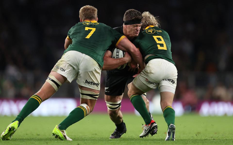 Scott Barrett of New Zealand is tackled by Pieter-Steph du Toit and Faf de Klerk of South Africa