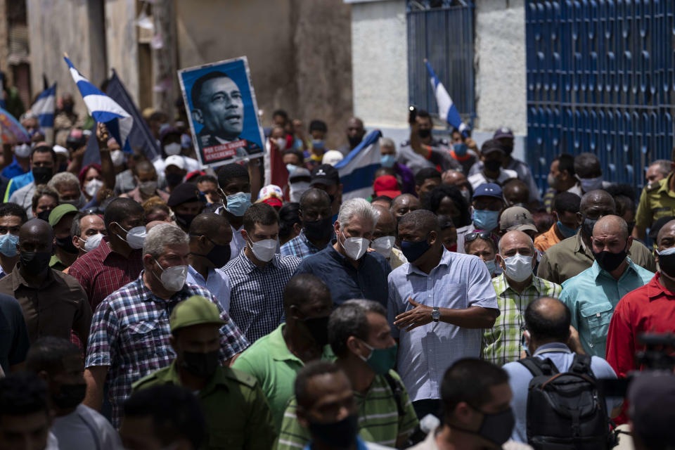 Cuba's President Miguel Diaz Canel walks with his followers after an anti-government protest in San Antonio de los Banos, Cuba, Sunday July 11, 2021. Hundreds of demonstrators went out to the streets in several cities in Cuba to protest against ongoing food shortages and high prices of foodstuffs, amid the new coronavirus crisis. (AP Photo/Ramon Espinosa)