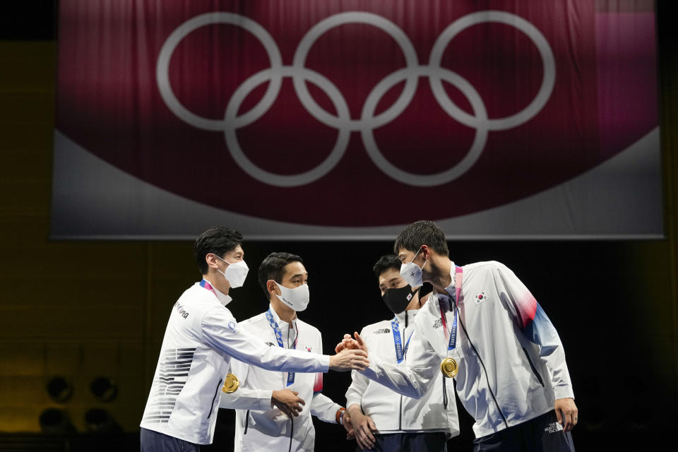 South Korea gold medalists celebrate on the podium of the men's Sabre team medal at the 2020 Summer Olympics, Wednesday, July 28, 2021, in Chiba, Japan. (AP Photo/Andrew Medichini)