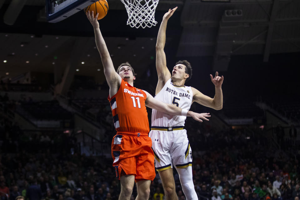 Syracuse's Joseph Girard III (11) drives past Notre Dame's Cormac Ryan (5) during the first half of an NCAA college basketball game on Saturday, Dec. 3, 2022 in South Bend, Ind. (AP Photo/Michael Caterina)