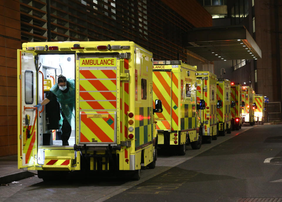 A paramedic opening the rear door of one of the ambulances queued outside the Royal London Hospital, in London.