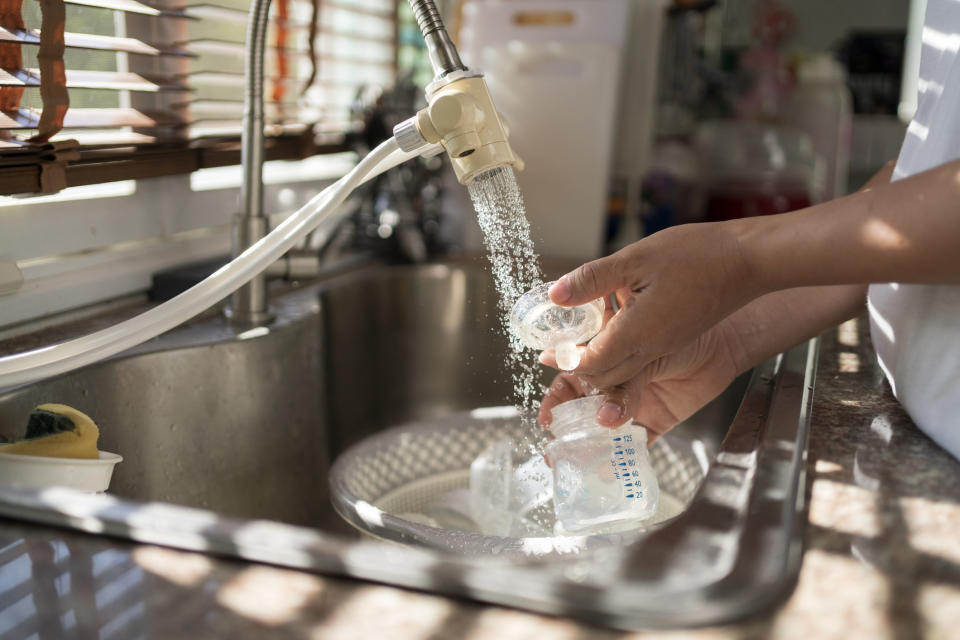 Someone washing baby bottle