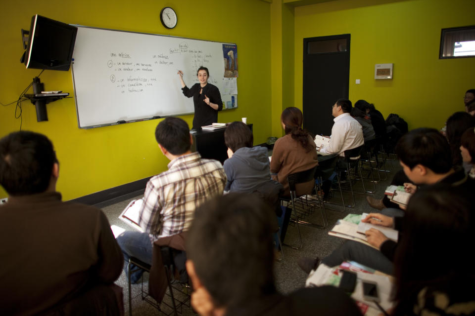 In this Sunday, Feb. 26, 2012 photo, an instructor teaches a French course in a classroom of Alliance Francaise, an organization that promotes French language and culture, in Tianjin, China. Thousands of people in China are trying to write their own ticket out of the country - in French. Chinese desperate to emigrate have discovered a backdoor into Canada that involves applying for entry into the country's francophone province of Quebec - as long as you have a good working knowledge of the local lingo. (AP Photo/Alexander F. Yuan)