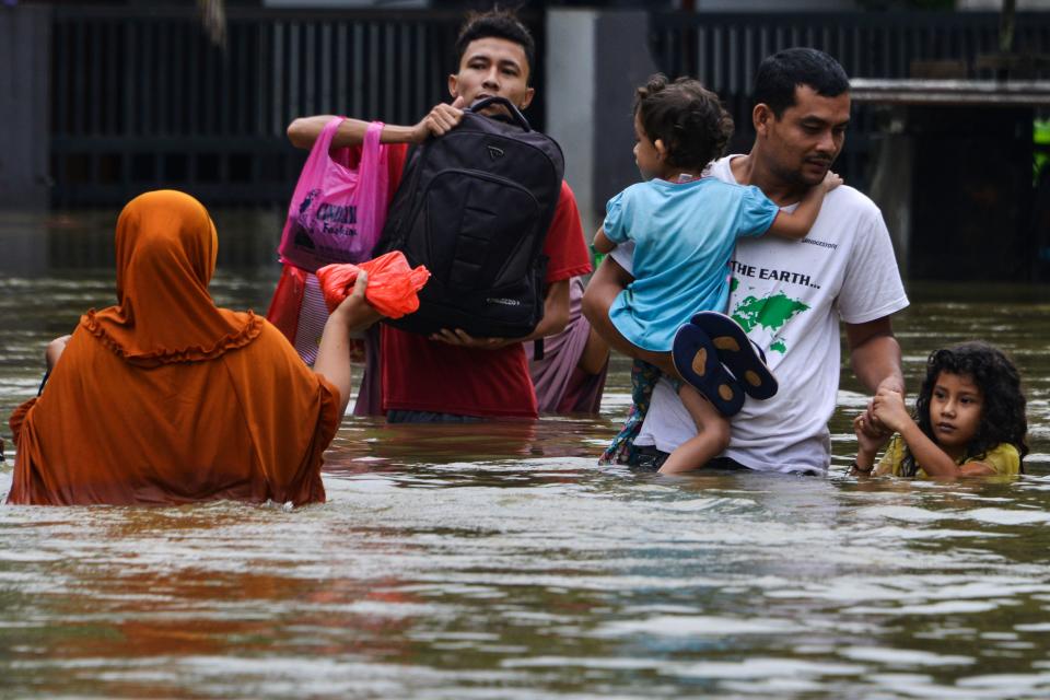 <strong>Floods in Indonesia: </strong>Floods ravaged Indonesia earlier this month, killing many and rendering many others homeless. A man and his children wade through floodwaters following three days of heavy rain in Banda Aceh on May 9, 2020.