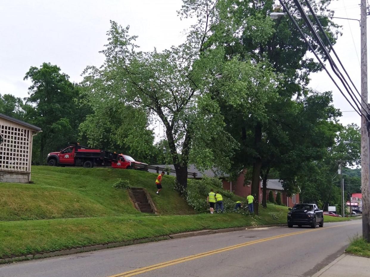 A Millersburg road crew clears fallen debris on South Washington Street on Tuesday after overnight storms knocked out power, closed roadways and shut down some businesses around Wayne, Holmes and Ashland counties.