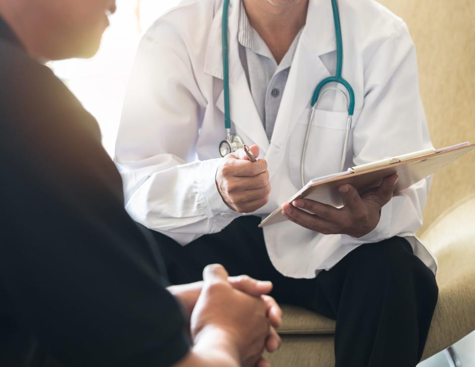 A doctor in a white coat talks to his patient.