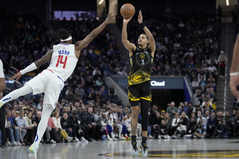 Golden State Warriors guard Jordan Poole (3) makes a 3-point basket while being defended by Los Angeles Clippers guard Terance Mann (14) during the second half of an NBA basketball game in San Francisco, Thursday, March 2, 2023. (AP Photo/Jeff Chiu)