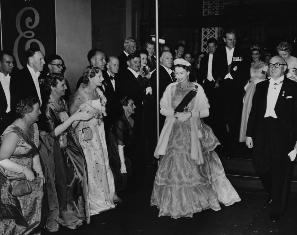 Australia, 1954: Queen Elizabeth II and the Duke of Edinburgh (behind) wearing formal dress as they leave City Hall following a Civic Ball, Hobart, circa 1954. (Getty Images)