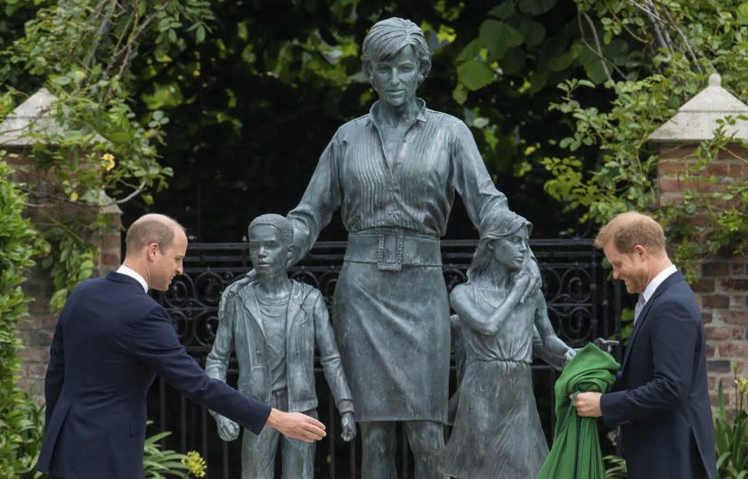 Two men in suits standing in front of a state of a woman and three children