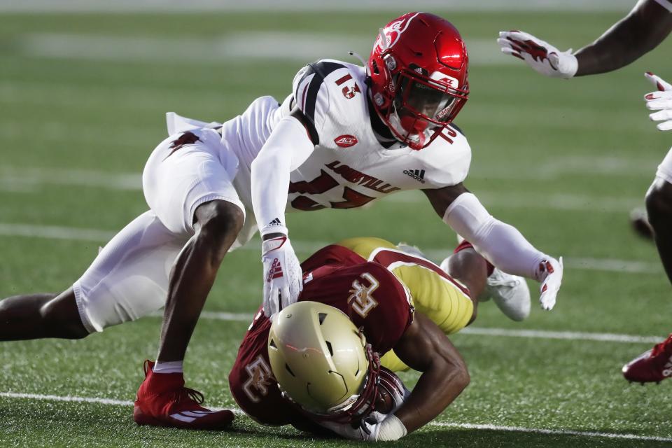 Louisville cornerback Kei'Trel Clark (13) tackles Boston College wide receiver Zay Flowers during the first half of an NCAA college football game, Saturday, Nov. 28, 2020, in Boston. (AP Photo/Michael Dwyer)