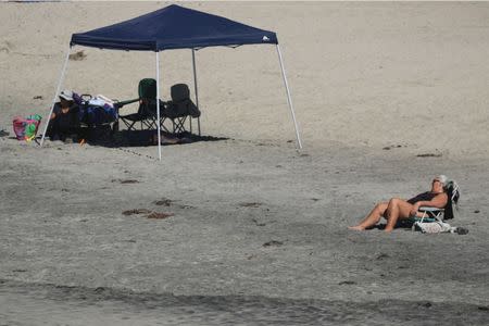 A woman cools off at the beach during a Southern California heat wave in Oceanside, California, U.S., October 24, 2017. REUTERS/Mike Blake