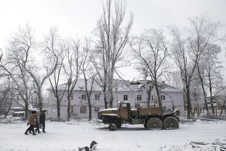 Locals walk past a destroyed Ukrainian army truck in the town of Vuhlehirsk, about 10 km (6 miles) to the west of Debaltseve, February 16, 2015. REUTERS/Baz Ratner