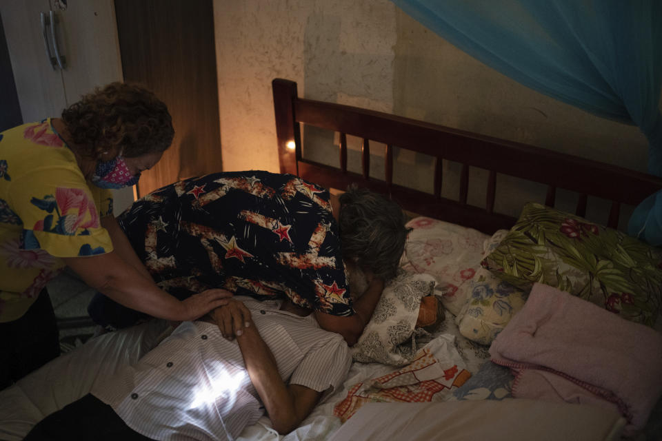 Relatives mourn over the body of Luis da Silva, 82, who had pre-existing health conditions and died at home after suffering from shortness of breath in Manaus, Brazil, Sunday, May 10, 2020. Per capita, Manaus is Brazil's major city hardest hit by COVID-19. (AP Photo/Felipe Dana)