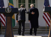 Brazil's President Jair Bolsonaro puts his hand on the back of U.S. President Donald Trump as they depart at the conclusion of a joint news conference in the Rose Garden of the White House in Washington, U.S., March 19, 2019. REUTERS/Kevin Lamarque