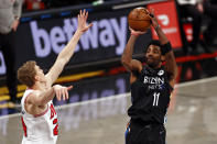 Brooklyn Nets guard Kyrie Irving (11) shoots over Chicago Bulls forward Lauri Markkanen during the second half of an NBA basketball game Saturday, May 15, 2021, in New York. (AP Photo/Adam Hunger)