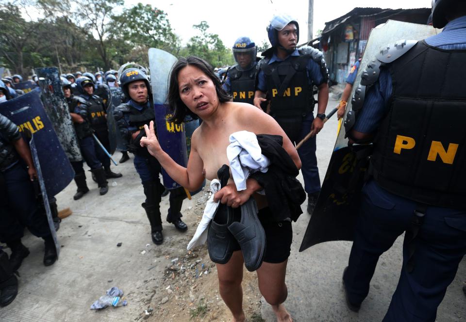 Filipino policemen clash with informal settlers