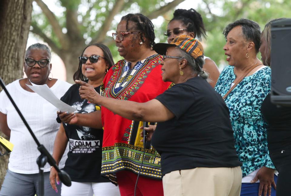 Crystal Hayman Simms (front, with hat) leads the singing of "Lift Every Voice and Sing" to open the Juneteenth celebration at the George Wilson Center and Park in Newark, Saturday June 17, 2023.