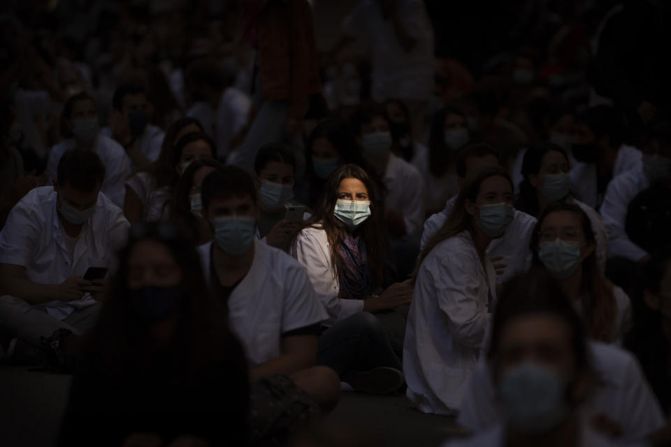 Medical residents sit in the middle of an avenue as they take part in a protest against their working conditions during a strike in Barcelona, Spain, Monday, Sept. 28, 2020. (AP Photo/Emilio Morenatti)