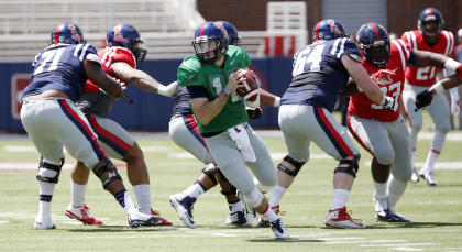 Mississippi Blue quarterback Chad Kelly (10) rolls out of the pocket as he tries to find an open receiver while Red defenders pursue during their spring college football game, Saturday, April 11, 2015, in Oxford, Miss. (AP Photo/Rogelio V. Solis)