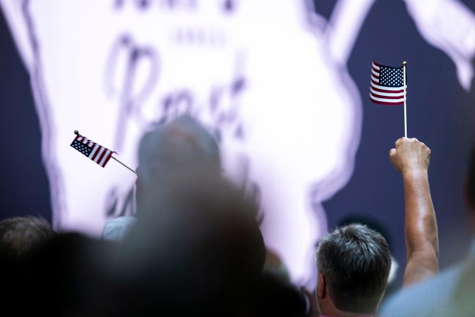 People wave American flags during the annual Roast and Ride fundraiser for U.S. Sen. Joni Ernst, Saturday, June 3, 2023, at the Iowa State Fairgrounds in Des Moines, Iowa.