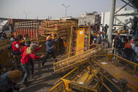 Protesting farmers remove police barricades as they march to the capital during India's Republic Day celebrations in New Delhi, India, Tuesday, Jan.26, 2021. Tens of thousands of farmers drove a convoy of tractors into the Indian capital as the nation celebrated Republic Day on Tuesday in the backdrop of agricultural protests that have grown into a rebellion and rattled the government. (AP Photo/Altaf Qadri)