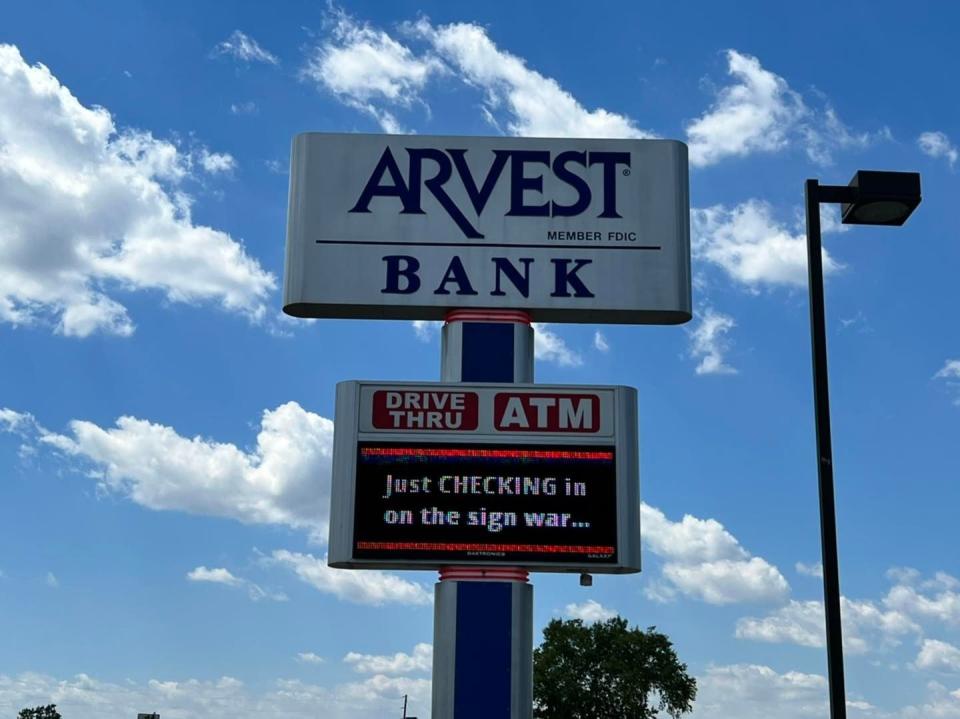 Arvest Bank's sign reads "Just checking in on the sign war" with checking in all caps