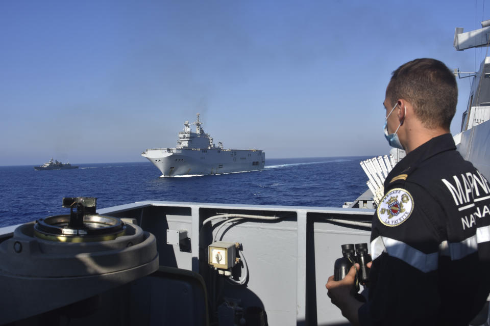 This photo provided Friday Aug.14, 2020 by the French Defense Ministry shows the French Tonnerre helicopter carrier, center, escorted by Greek and French military vessels during a maritime exercise in the Eastern Mediterranean, Thursday, Aug. 13, 2020. Greece's prime minister warmly thanked France Thursday for boosting its military presence in the eastern Mediterranean, where Greek and Turkish warships are closely shadowing each other over a Turkish energy exploration bid in waters Athens claims as its own. (French Defense Ministry via AP)