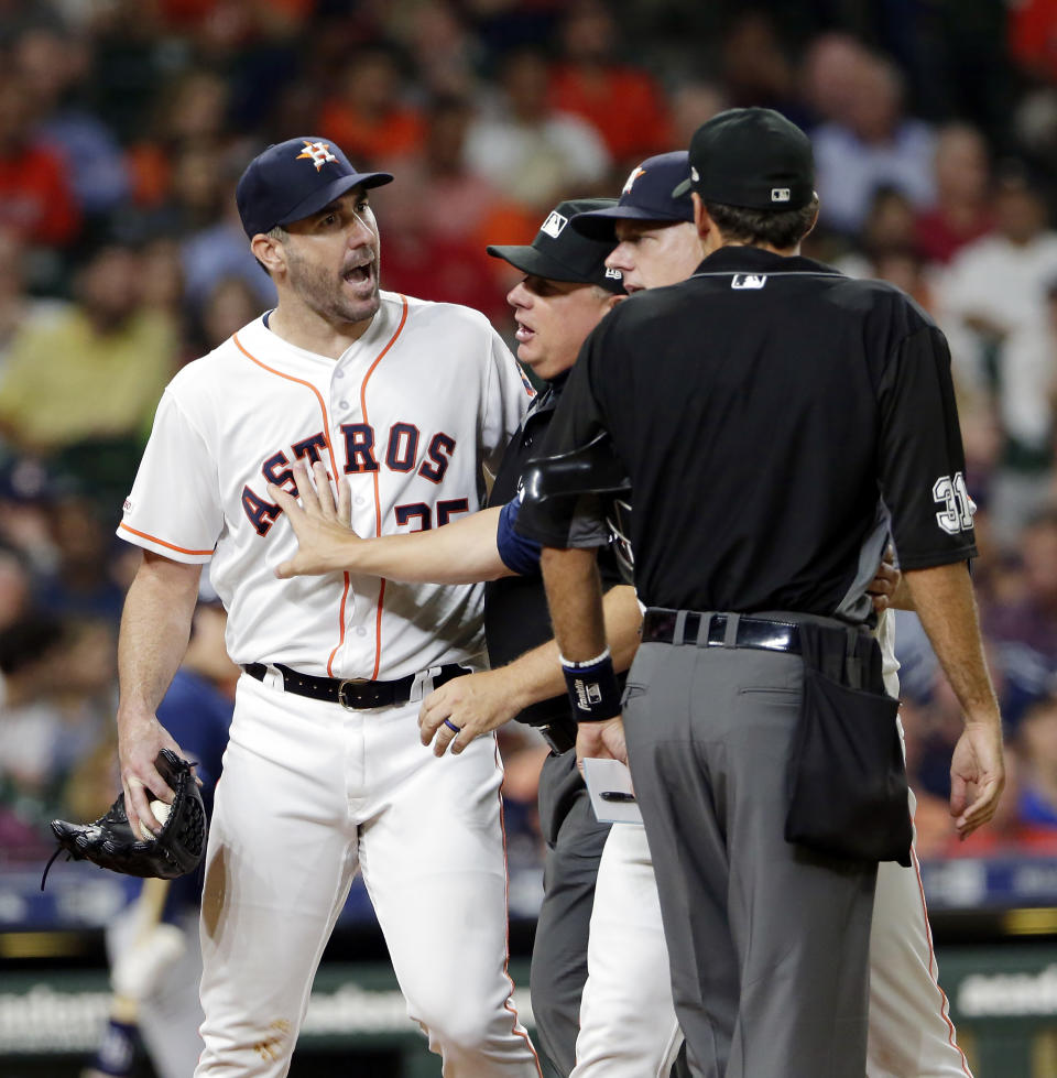 Houston Astros starting pitcher Justin Verlander, left, is held back by first base umpire Greg Gibson and manager A.J. Hinch as Verlander argues with home plate umpire Pat Hoberg after he ejected Verlander during the sixth inning of a baseball game against the Tampa Bay Rays Tuesday, Aug. 27, 2019, in Houston. (AP Photo/Michael Wyke)