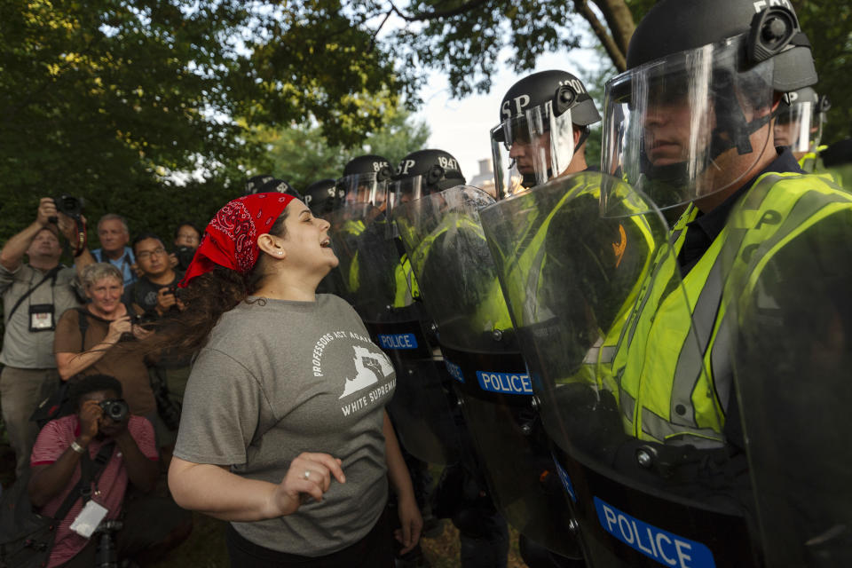 Emily Filler attempts to dissuade state police from advancing on students rallying on the grounds of the University of Virginia on the anniversary of the "Unite the Right" rally in Charlottesville, Va. Saturday, Aug. 11, 2018. The city of Charlottesville plans to mark Sunday's anniversary of a deadly gathering of white supremacists with a rally against racial hatred. (Craig Hudson/Charleston Gazette-Mail via AP)