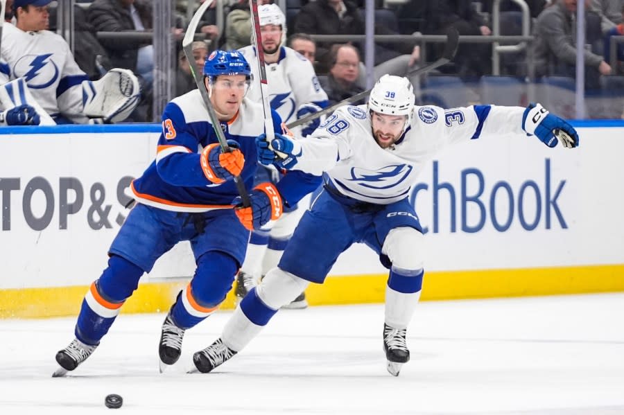 Tampa Bay Lightning’s Brandon Hagel (38) fights for control of the puck with New York Islanders’ Mathew Barzal (13) during the first period of an NHL hockey game Saturday, Feb. 24, 2024, in Elmont, N.Y. (AP Photo/Frank Franklin II)