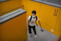A man wearing a face mask to protect against the coronavirus walks up a staircase at an outdoor shopping area in Beijing, Saturday, Aug. 1, 2020. China reported a more than 50% drop in new cases of COVID-19 on Saturday in a possible sign that its latest major outbreak in the northwestern region of Xinjiang may be waning. (AP Photo/Mark Schiefelbein)