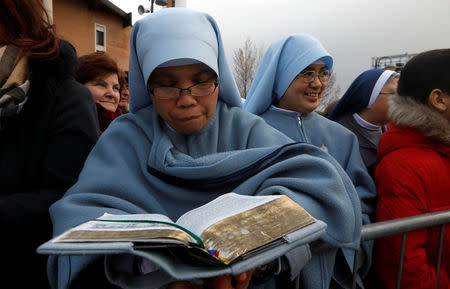 A nun reads the Bible as she waits for the arrival of Pope Francis in Pietrelcina, Italy March 17 2018. REUTERS/Ciro De Luca