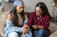 Katherine, left, and Jennifer Guzman hold hands while talking about their mother Lunisol Guzman and life after her passing from symptoms COVID-19, Thursday, Sept. 17, 2020, in Newark, N.J. Four-year-old Zavion and 2-year-old Jazzmyn have been taken in by the oldest of Lunisol Guzman's other three children, Katherine and Jennifer. Lunisol Guzman had adopted them when she was in her 40s. (AP Photo/Mary Altaffer)