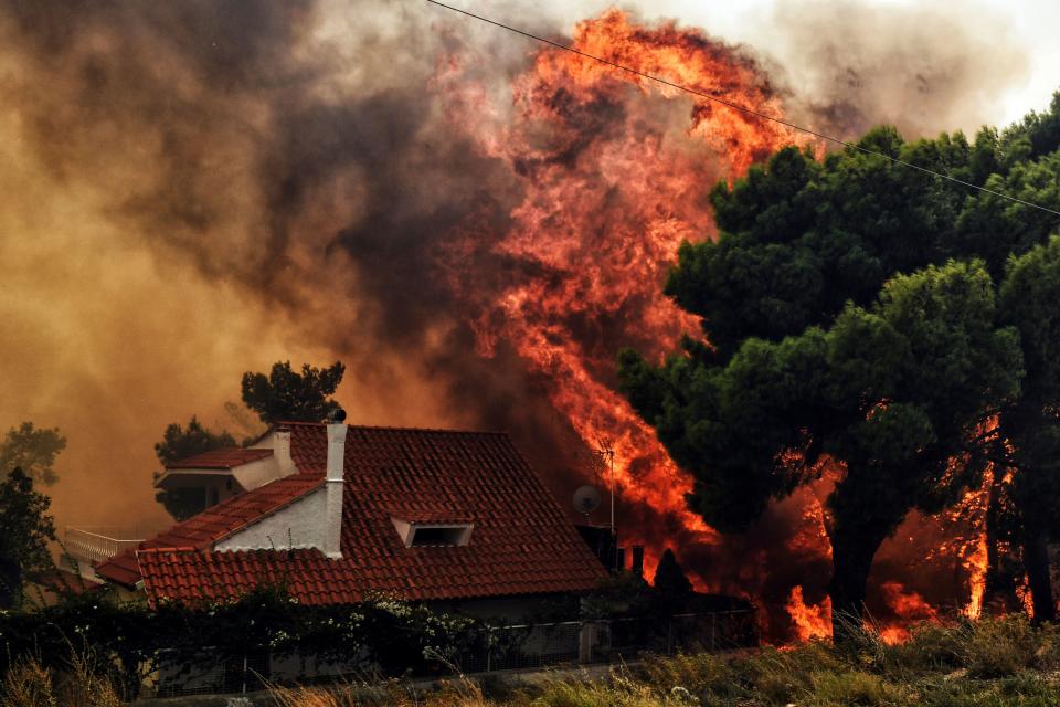 <p>A house is threatened by a huge blaze during a wildfire in Kineta, near Athens, on July 23, 2018. (Photo: Valerie Gache/AFP/Getty Images) </p>