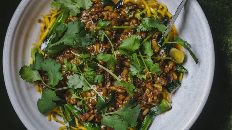 bowl of noodles with sauce and cilantro