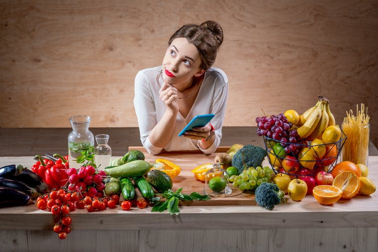 Young woman uses smartphone to track food calories.