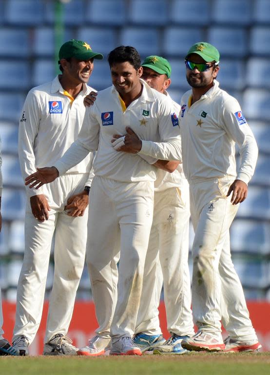 Pakistan cricketer Azhar Ali (centre) celebrates with teammates the dismissal of Sri Lanka's Dimuth Karunaratne during the opening day of the third and final Test match in Pallekele on July 3, 2015