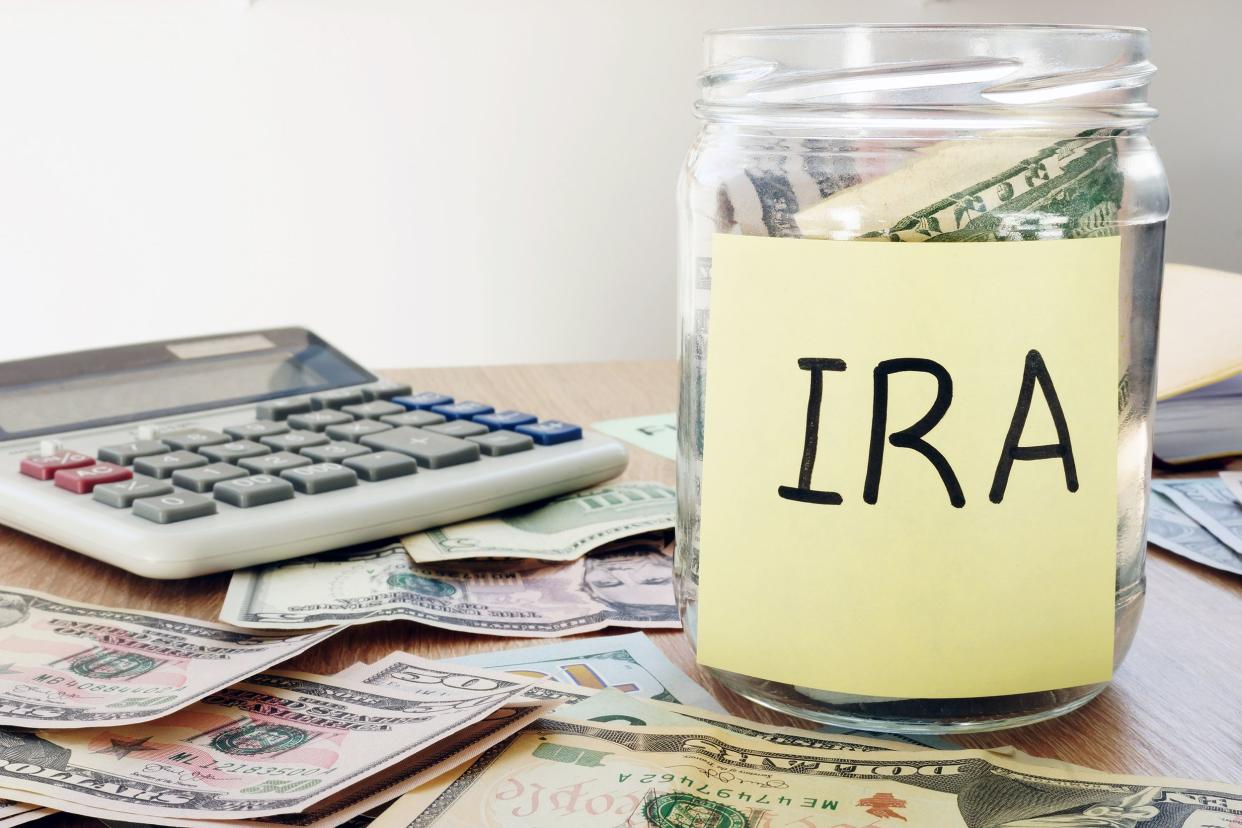 IRA jar with money next to a calculator