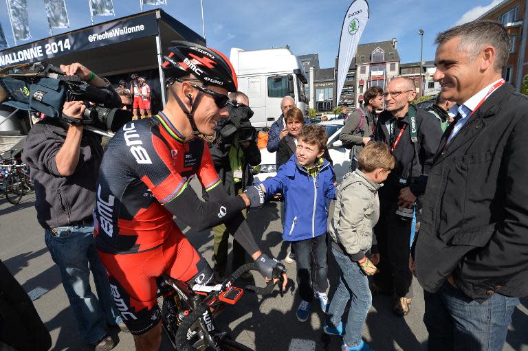 Belgian cyclist Philippe Gilbert shakes hands with a young fan before the start of the Fleche Wallonne cycling race in Bastogne on April 23, 2014