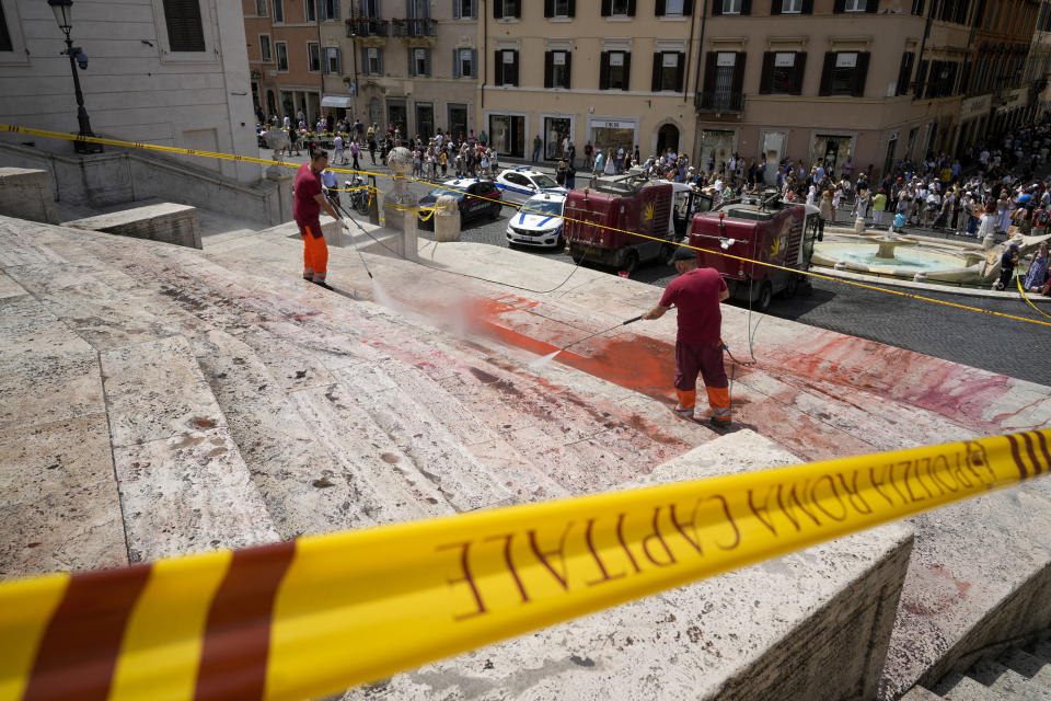 Rome municipality workers clean the Spanish Steps after activists dumped red paint over them protesting against violence on women, in Rome, Wednesday, June 26, 2024. (AP Photo/Andrew Medichini)
