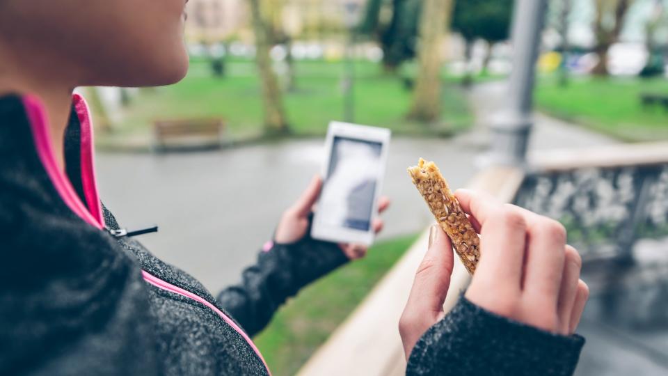 Woman eating protein or cereal bar